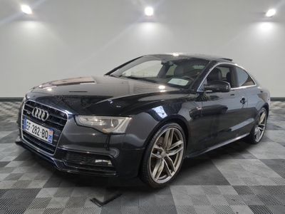 l'audi noire est garée sur le sol en damier d'un garage