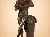 une statue en bronze représentant un homme tenant un seau de raisins