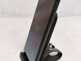 a close up of a cell phone on a stand on a table