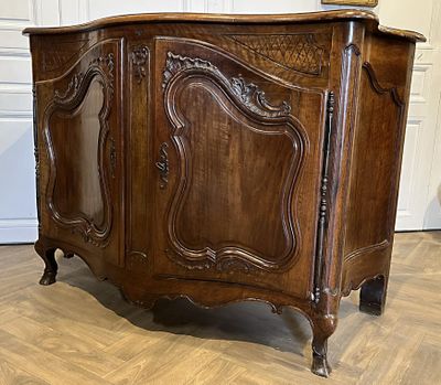 une vieille armoire en bois posée sur un sol en bois dur