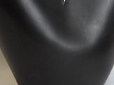 a close up of a black vase with a white flower in it