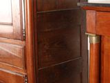 a tall wooden cabinet next to a bed in a room