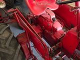 a red tractor that is parked in a garage