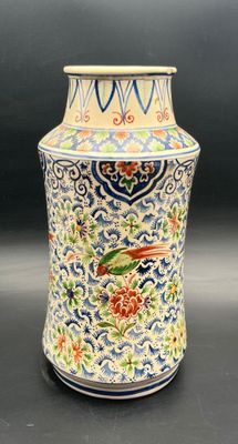 a large vase with a bird on it on a table