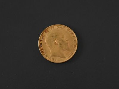 a close up of a gold coin on a black surface