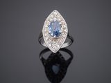 a blue sapphire and diamond ring on a black surface