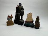 several figurines of people sitting on top of a white surface