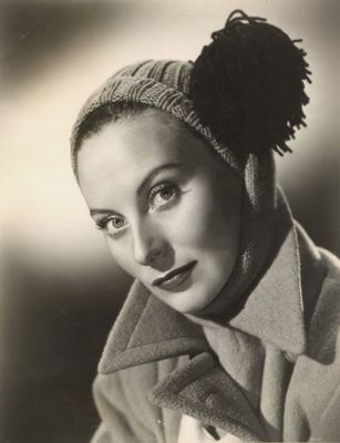 photographie en noir et blanc d'une femme portant un chapeau et un manteau