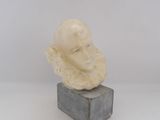 a white marble bust of a man sitting on top of a cement block