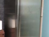 a stainless steel refrigerator in the corner of a room
