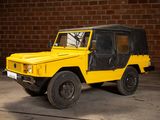 a yellow jeep parked in front of a brick wall