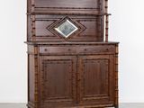 une vieille armoire en bois surmontée d'un miroir