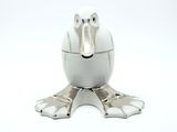 a white bird shaped container with metal feet on a white surface