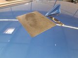 a picture of a blue car that has a sticker on the hood