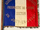 flags are hanging on a wall in a room with a white wall