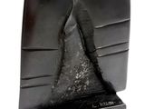 une sculpture noire représentant une montagne posée sur un livre