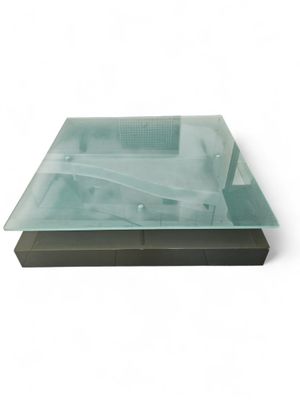une table en verre avec un piètement en métal sur fond blanc