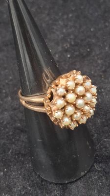 bague plaquée or ornée de perles disposées en forme de cône sur un fond noir
