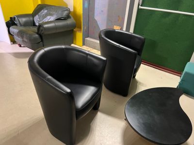 deux chaises noires et une table dans une pièce