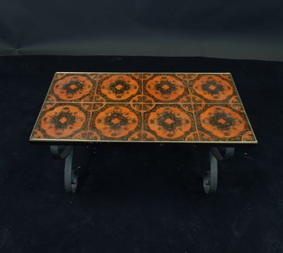 an orange and black tiled coffee table with wheels on a black background