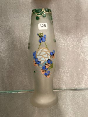 a glass vase with flowers on it on a shelf