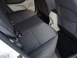 the back seats of a white car with a black seat belt