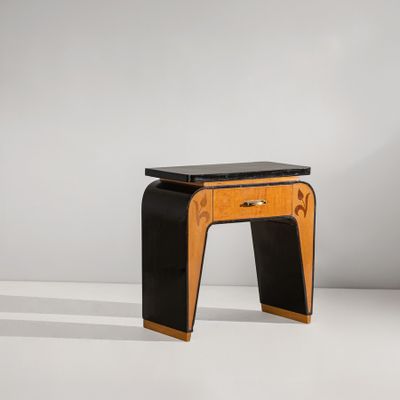un tabouret noir et en bois, avec une assise noire posée sur une surface blanche
