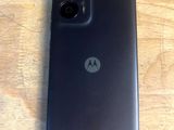 a close up of a motorola phone sitting on a wooden table