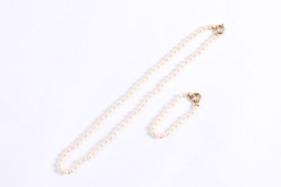 a close up of a necklace and a pair of earrings on a white surface