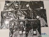 plusieurs sacs contenant des vêtements noirs et blancs posés sur une table