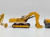 four toy excavators that are lined up on a white surface