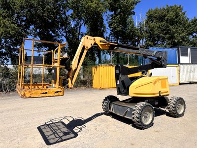 une petite machine jaune garée sur la terre battue