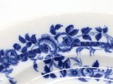 a close up of a blue and white plate with flowers on it