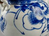 a blue and white tea pot with a bamboo handle