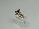a close up of a diamond and sapphire ring on a clear acrylic stand