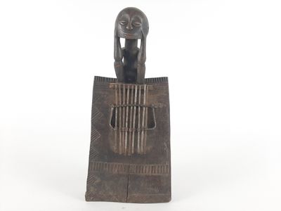 an image of a statue of a woman sitting on top of a piece of wood