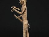 a bronze figurine of a woman holding a bird