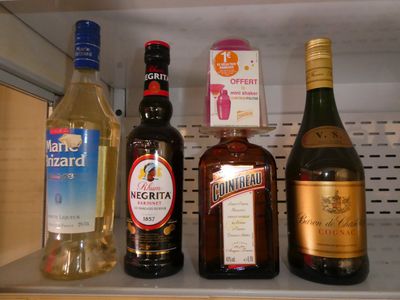 des bouteilles d'alcool sont alignées sur une étagère dans un réfrigérateur