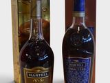 deux bouteilles d'alcool posées l'une à côté de l'autre devant une boîte