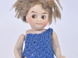 a small doll that is wearing a blue dress and socks