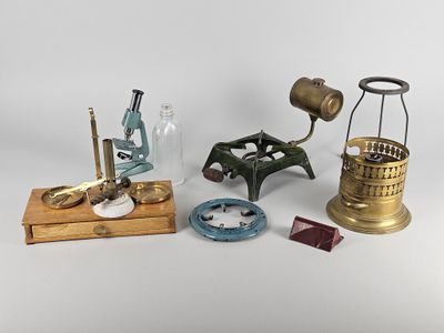 plusieurs types de microscopes et d'autres objets posés sur une surface blanche