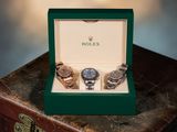 trois montres posées dans une boîte, sur une valise