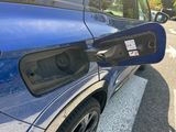a blue car that has an electric charger attached to it
