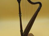 a small wooden harp on a stand on a yellow background