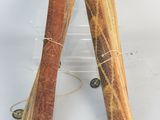 two wooden incense sticks wrapped in twine on a white surface