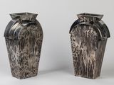 two vases sitting side by side on a white surface