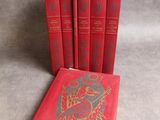 three red books sitting next to each other on a gray surface