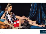 a woman sitting on a bed with a dog and a bottle of perfume