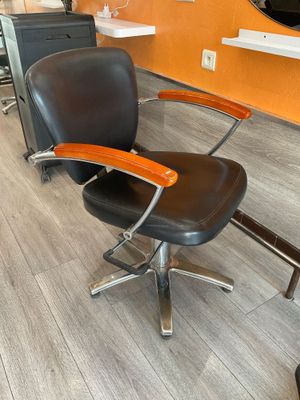 une photo d'un salon de coiffure avec un fauteuil et un miroir