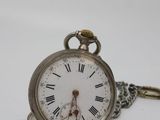 a silver pocket watch with roman numerals on it